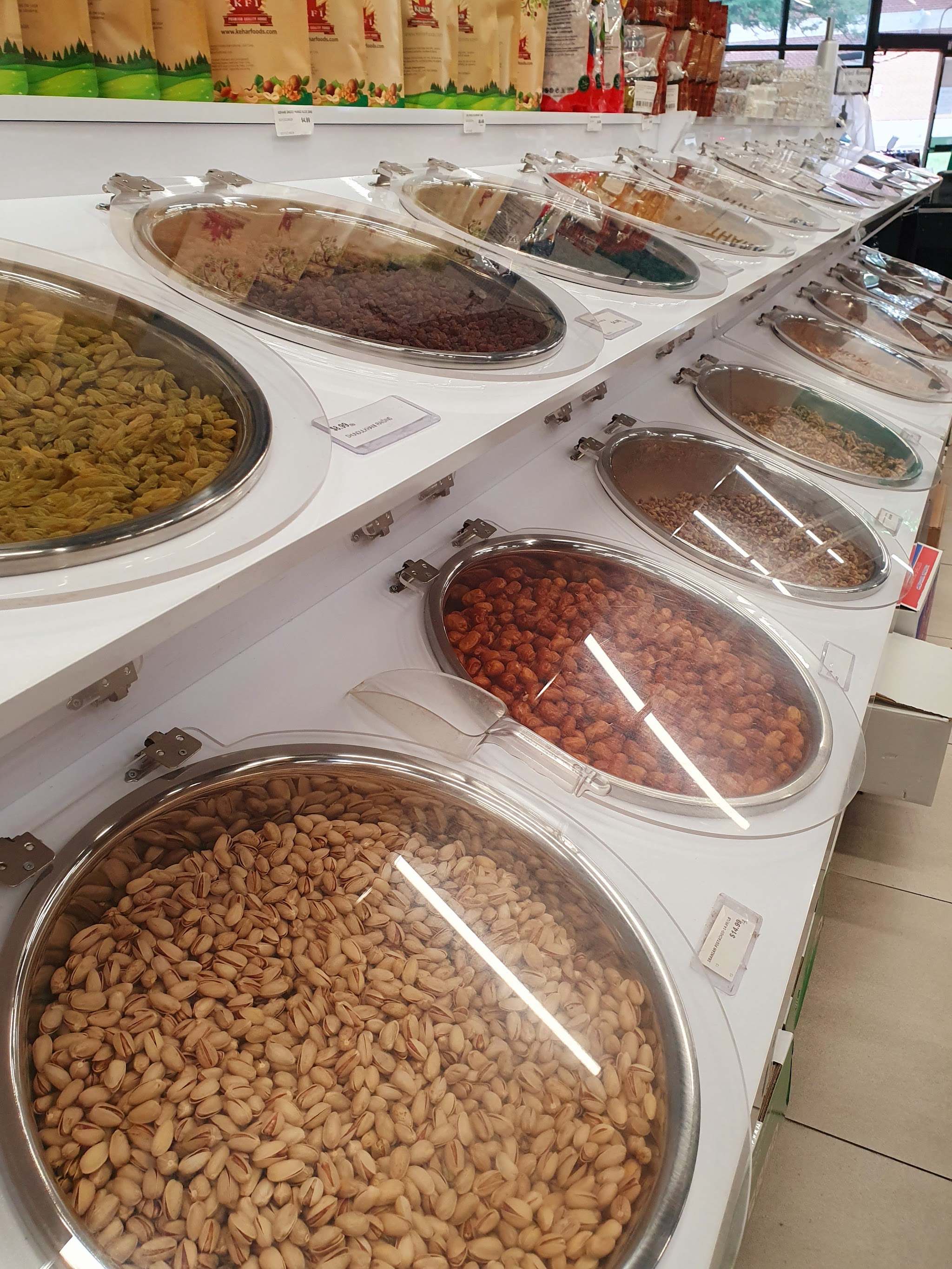 Bulk bins of premium nuts and dried fruits including pistachios, almonds, and raisins at Kabul Farms