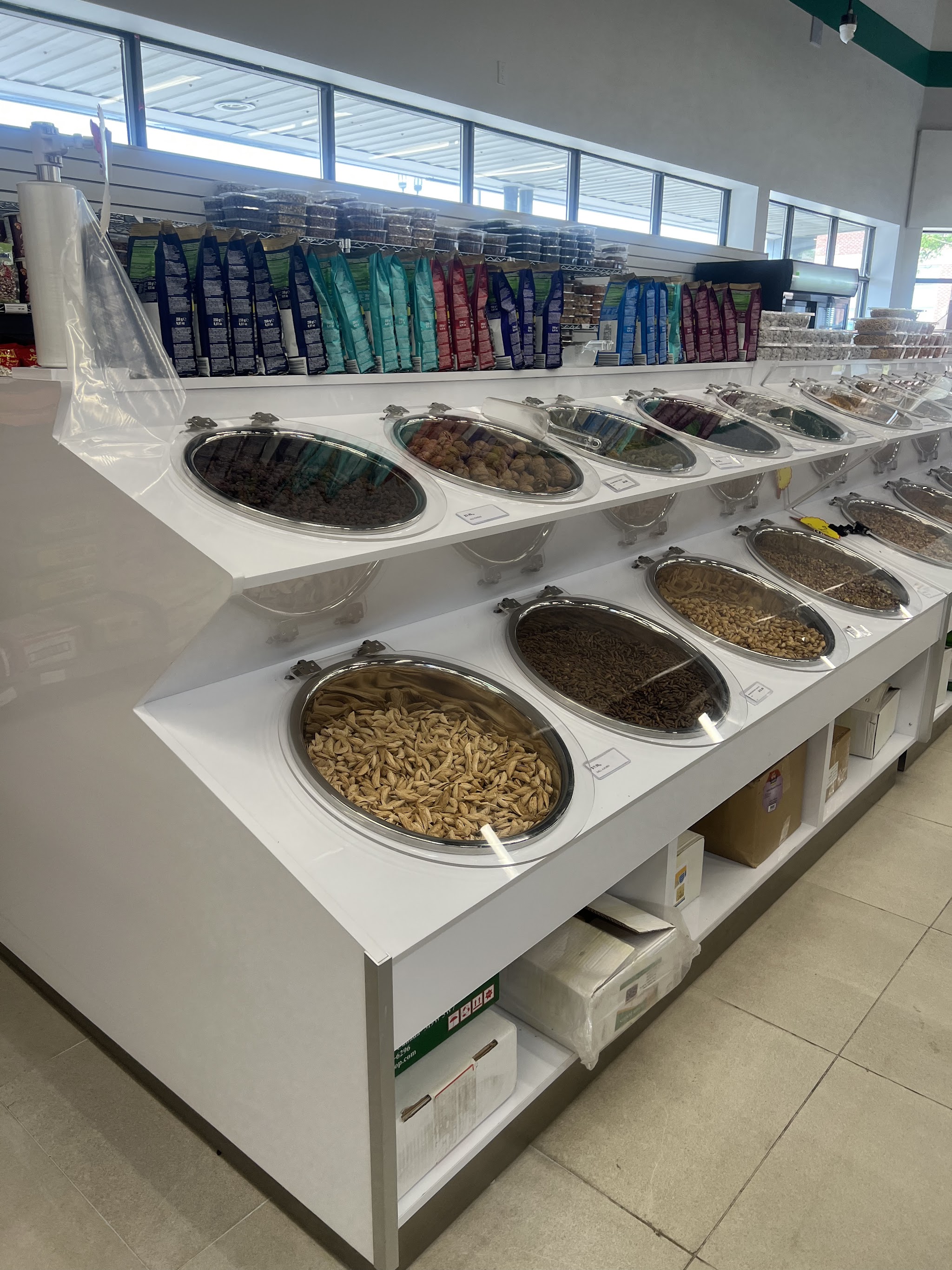 Bulk bins of premium nuts, dried fruits, and seeds at Kabul Farms with self-serve scoops