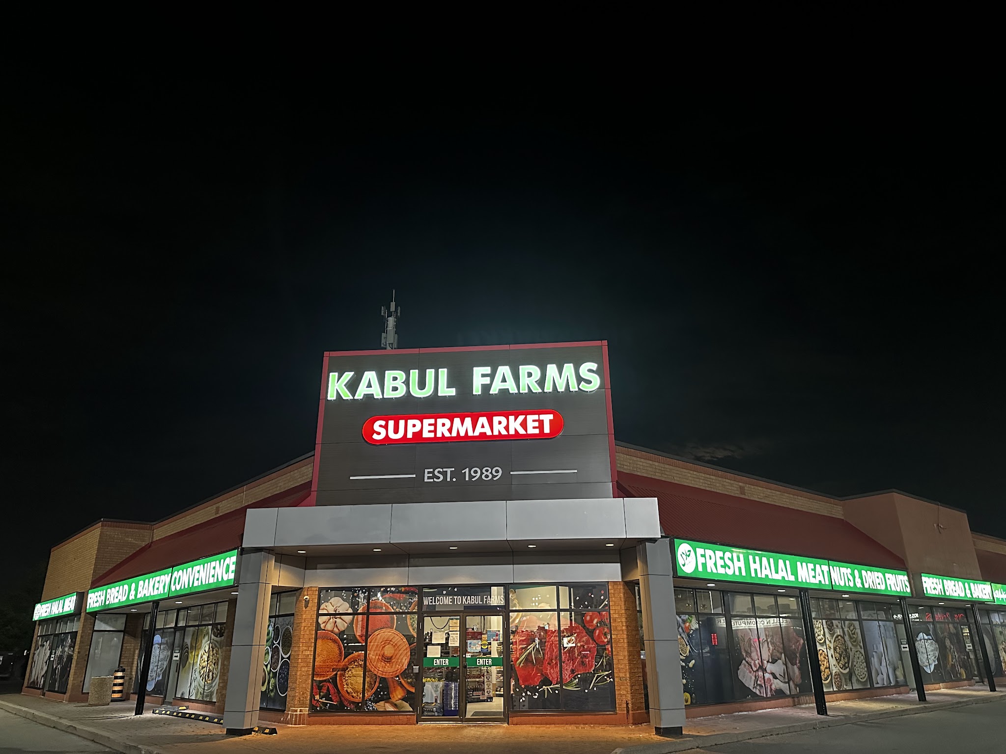 Kabul Farms Supermarket at night with illuminated signage showing KABUL FARMS SUPERMARKET EST. 1989